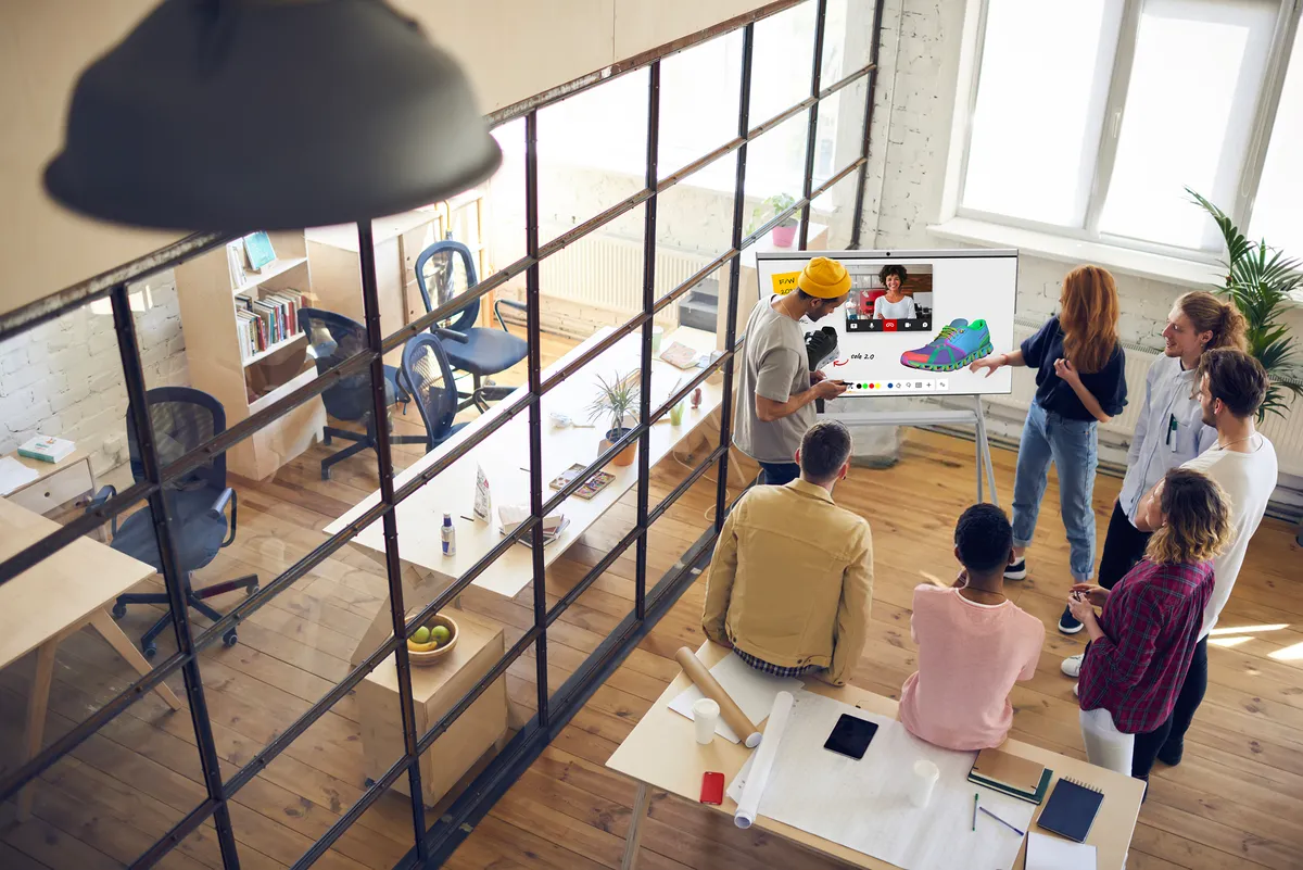 A group of people brainstorming around a board with Mago on it