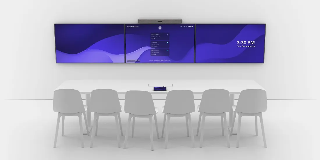 A boardroom with three displays side by side, each showing the Mago home screen: the room name, the agenda of the day and the time.